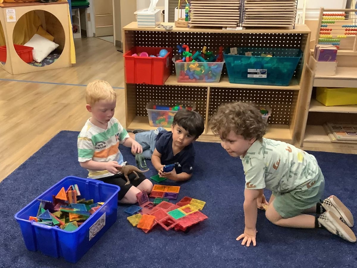 Preschoolers building with magnetic tiles